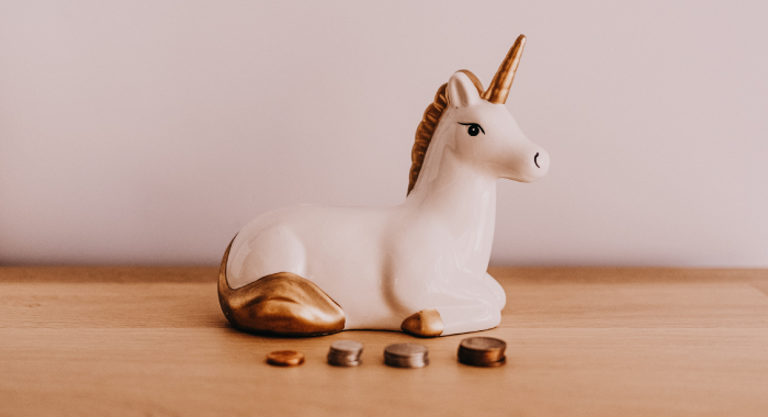 unicorn figurine with change stacked in front of it