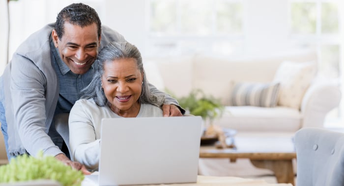 elderly couple looking at a laptop