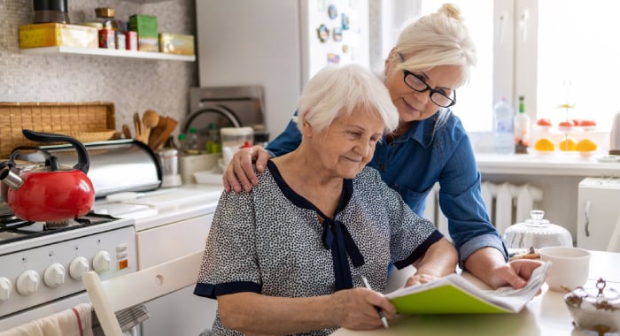 Caregiver helping an older person with paperwork